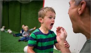 A child getting his cheek swabbing for a paternity test.
